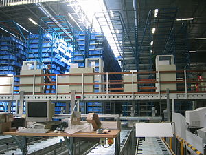 Instalações Logísticas Imagem mostra mercadorias empilhadas em paletes com empilhadeira, concebidas por um Warehouse Management System( WMS), em português - literalmente: sistema de automação e gerenciamento de depósitos, armazéns e linhas de produção.