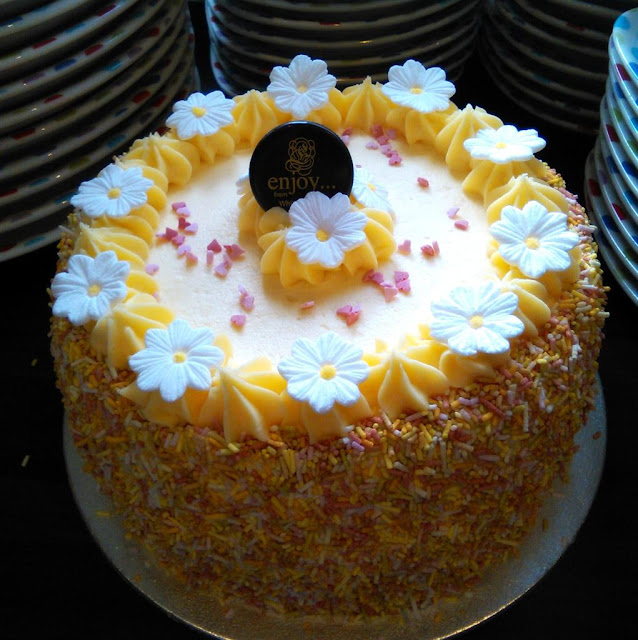 lemon butter cream cake with colourful sprinkles and white daisies