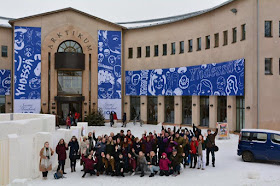 Arktikum-museo, jonka edessä seisoo joukko ihmisiä poseeraamassa kameralle