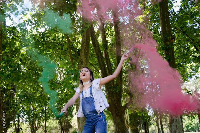 Chica de 15 años con bengalas de humo de colores en el bosque