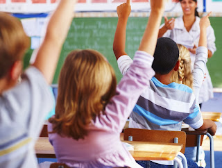 Students raising their hands in the classroom