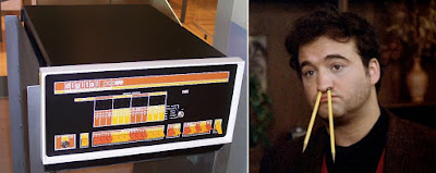 DEC PDP-8 computer next to Blutarsky from Animal House, with pencils up his nose