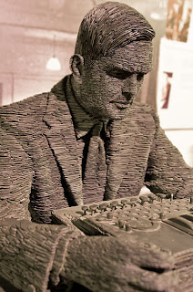 That's Alan Turing, or rather, a staute of him.