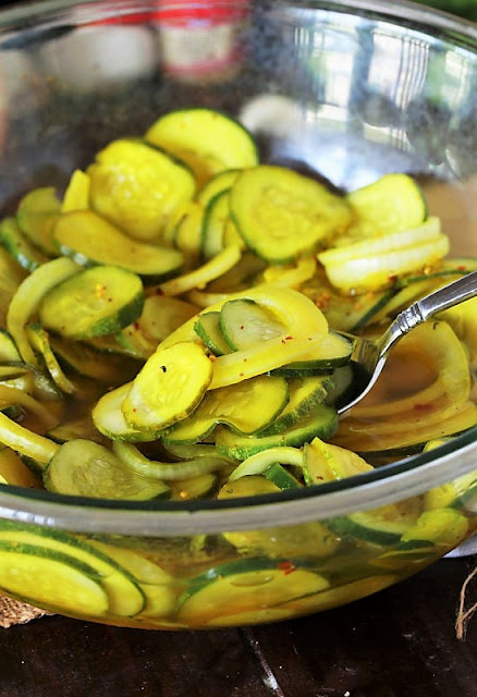 Bowl of Easy Refrigerator Pickles with Serving Spoon Image