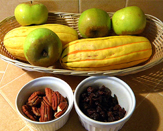Basket of Delicata squash and apples, dishes of raisins and pecans