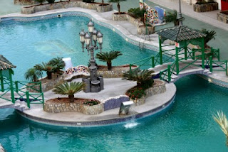 Hotel swimming pool with palm trees and a fountain