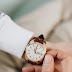 A person winding his wristwatch