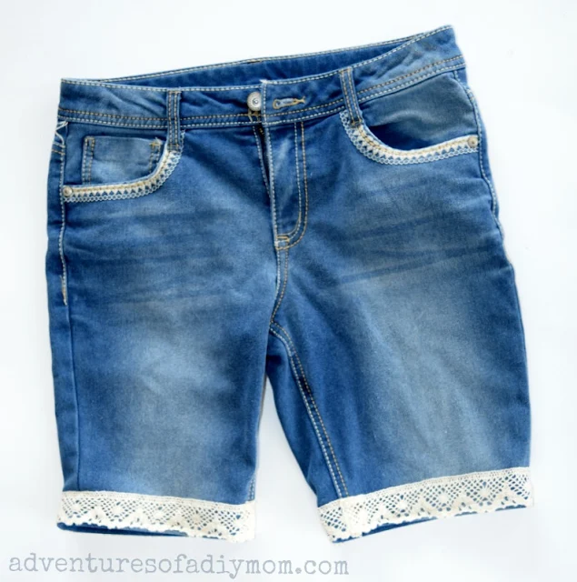 How to make cutoff shorts with a lace accent. An easy DIY that's so stinkin' cute for your little girls. #cutoffshorts #shortsforkids #diycutoffs #cutofftutorials #howtomakecutoffs #cutoffshortstutorial #cutoffshortideas #adventuresofadiymom