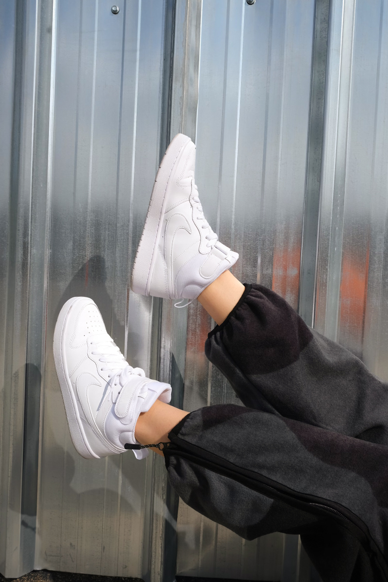 a pair of white sneakers on women feet