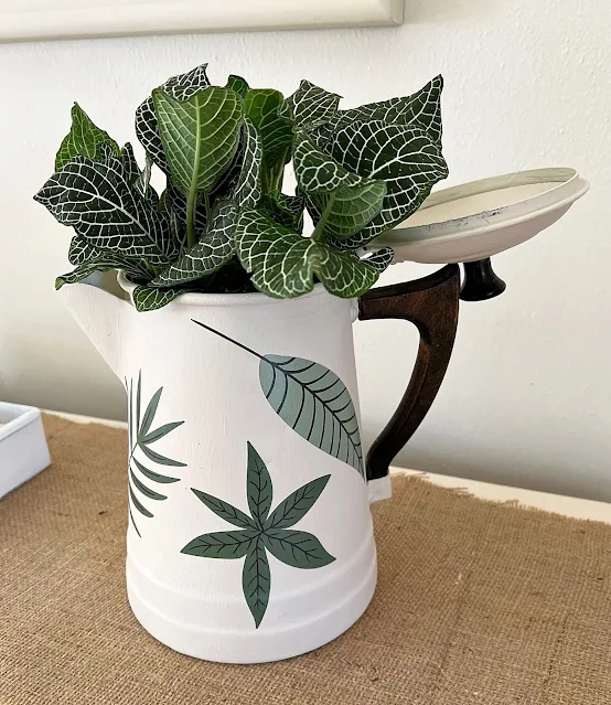 Photo of an coffeepot upcycled and repurposed with paint and decor transfers to hold plants.