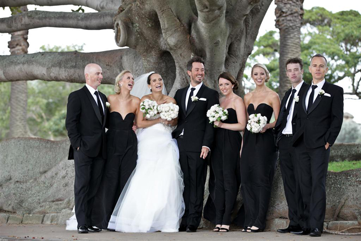 The bridal party photo shoot took place by the water The grooms suit was 