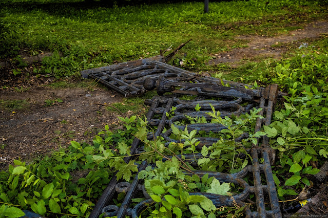 Чугунная ограда лежит на траве