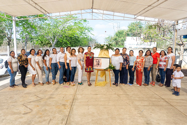 Un grupo de docentes posan con la placa connemorativa por los 50 años del nombre del plantel