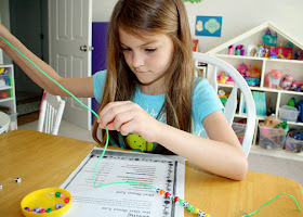 Tessa laced appropriately colored pony beads and alphabet beads onto plastic cord to represent the various lines of the Girl Scout Law. Afterward, we fashioned the cord into a necklace to help her memorize the Law.