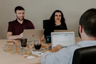 Team of professionals planning affiliate marketing strategies using laptops and data charts
