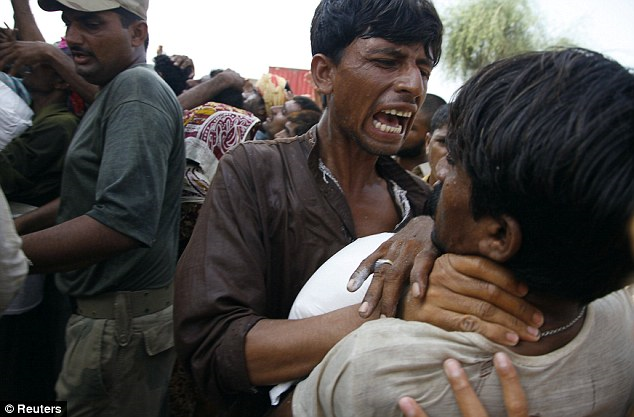 Desperate: Refugees fight to get food donated by a local charity in the village of Karamdad Qureshi in Punjab province, 22 August 2010. Some 20 million people have been affected by the worst flooding in Pakistan's history. Reuters