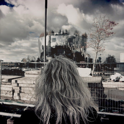 Vrouw met grijs haar bekijkt spiegelend gebouw