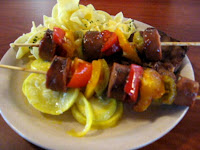 Click to enlarge - Sausage brochette on a bed of yellow squash and noodles
