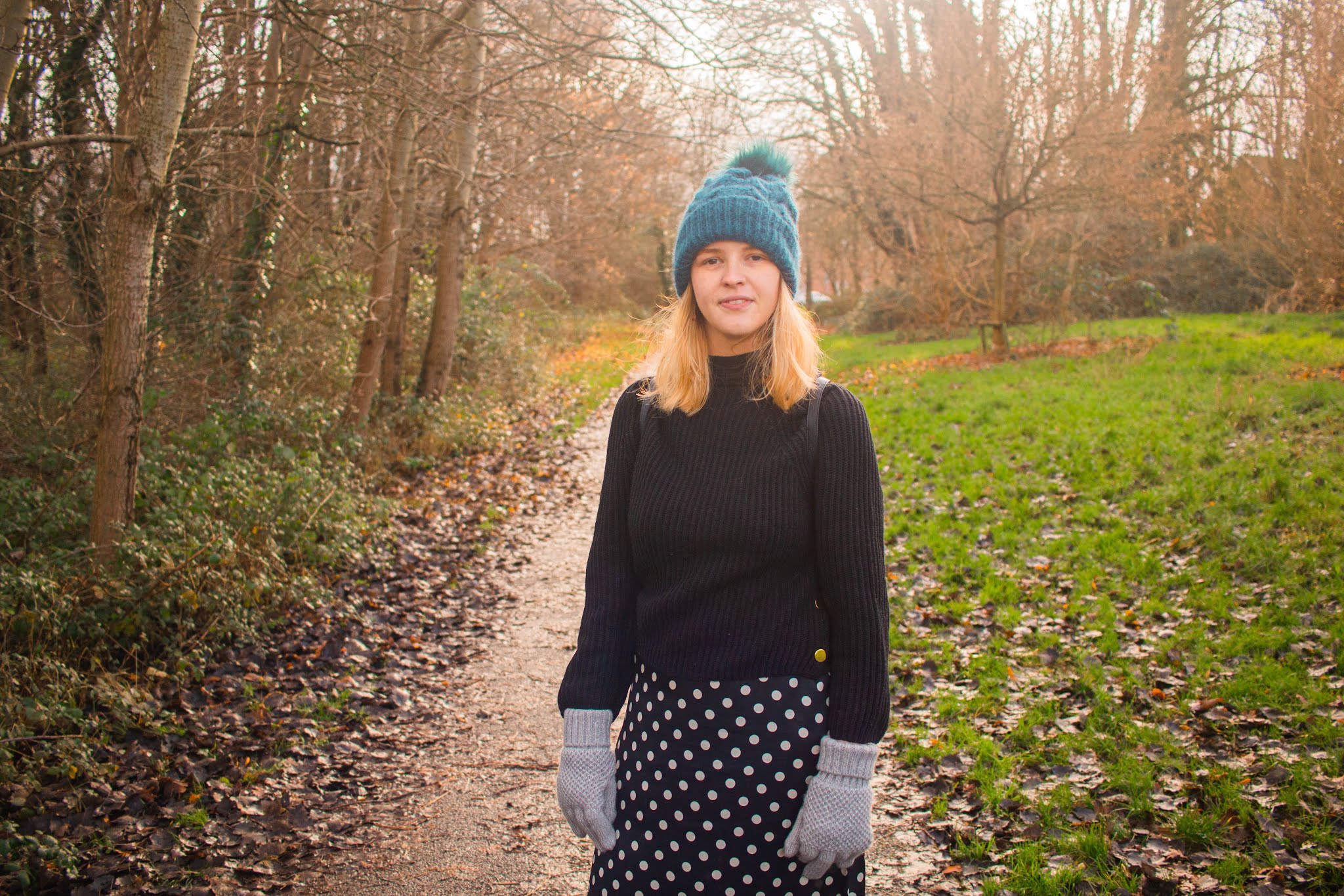 fashion blogger chloeharriets wearing polka dress, jumper and hat, walking through nature, smiling, how to relieve stress blog self-care intentional living