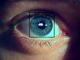 Image of a computer mock up of an eye being tracked with a Space Invader reflected in the eye.