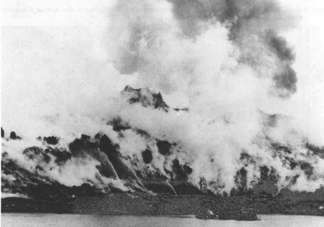 View to the south from Vestmannaeyjar's outer harbor on May 4, 1975. Seawater is being sprayed directly onto the lava flow front to arrest infilling of the harbor entrance.