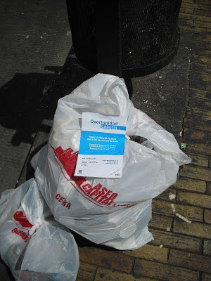 Petrograd — Colombia's new capital? Out with the old, in with the new. An Acueducto leaflet looking for workers sits on top of a rubbish bag from one of the current providers