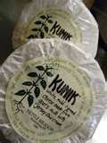 A photo of two wrapped buttons of Kunik goat cheese.