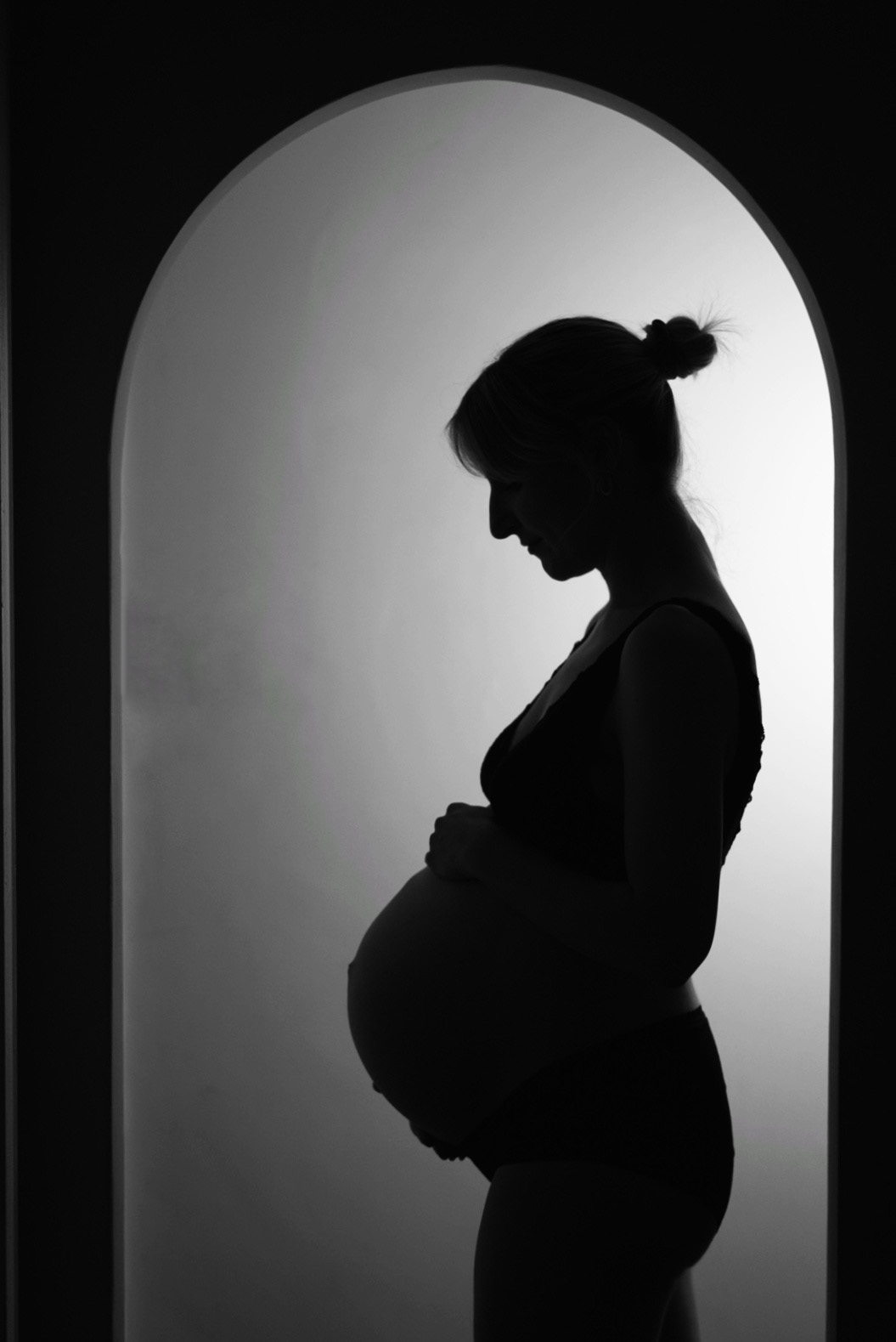 a silhouette of a woman holding her pregnant belly at 39 weeks