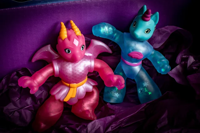 Close up of a pink dragon called Glyde and a blue unicorn called Roxy