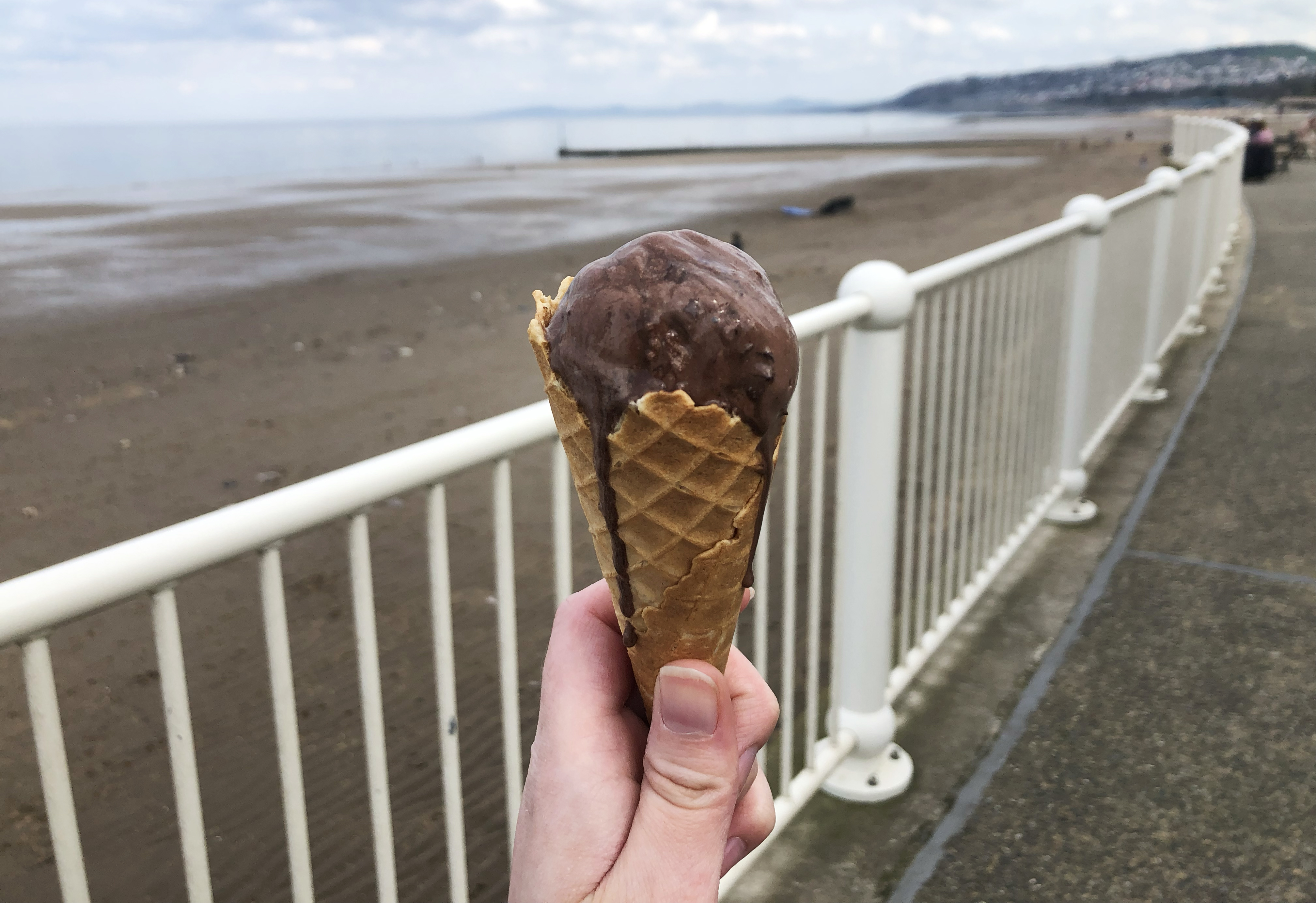 Holding my melting Chocolate Ice Cream in front of the beach
