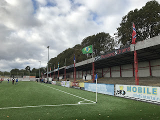 Flags of the world displayed on one of the stands at Carshalton FC