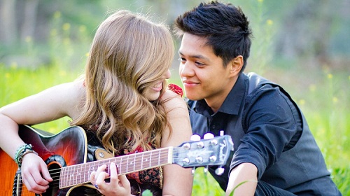 Romantic Young Couple Playing Guitar