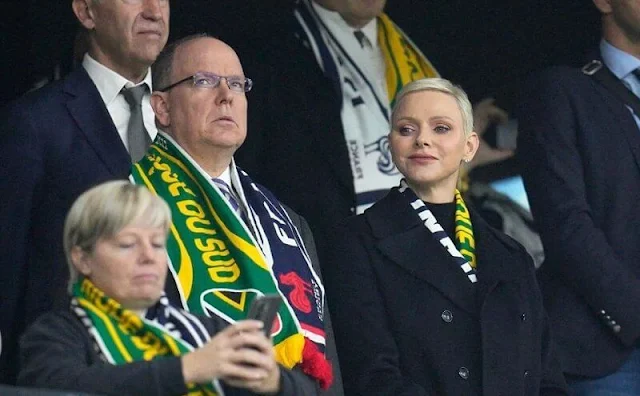Princess Charlene wore a navy wool coat by Akris. Black leather trousers. France had not beaten South Africa since 2009