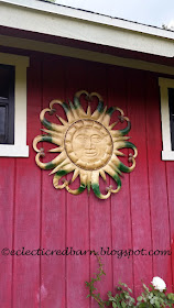 Eclectic Red Barn: Metal sun hanging on the barn