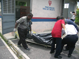 man in body bag being carried out of TNB electric sub-station