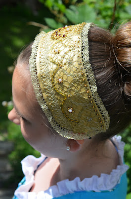 Ein Mädchen trägt ein goldbesticktes Haarband.