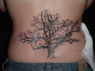 This is an intricate dead tree tattoo at the lower back.