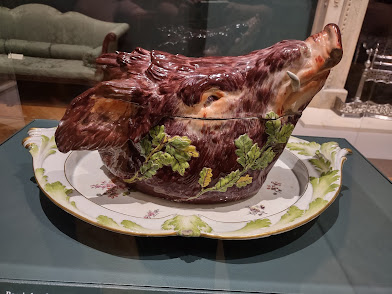 Landscape photo, side on, of a porcelain tureen in the shape of a pig's head