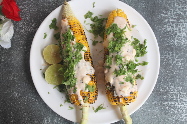 Garnishing Mexican Sweet Corn with Lime Juice and Cilantro
