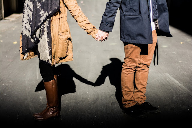 couple holding hands apart opposite not facing distant