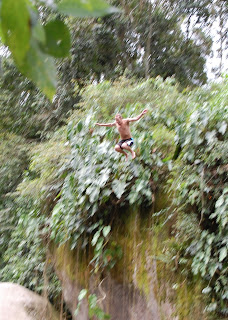 Noah jumping off rock into pool below in Paraty.