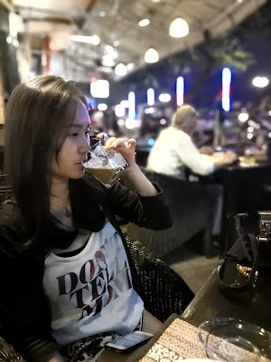 Stepheny drinking Cambodia coffee in a cafe at night, near to riverside bar