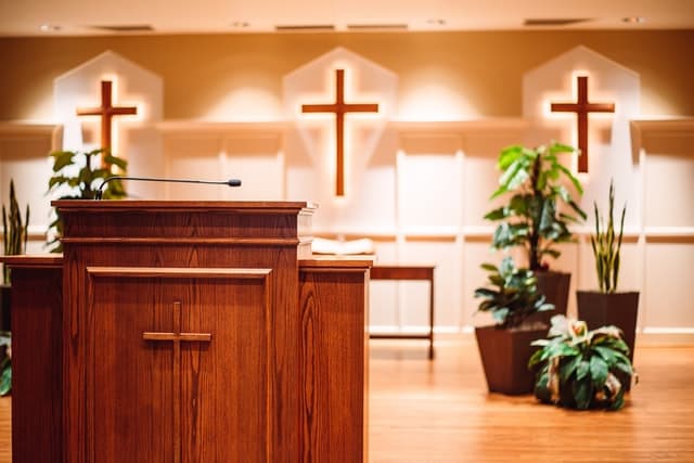 brown wooden cross on brown pulpit