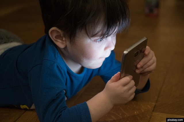 Un niño pequeño con un teléfono móvil