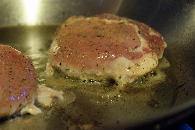 Showing the the pork chop is ready to flip when the white makes it half way up the chop.