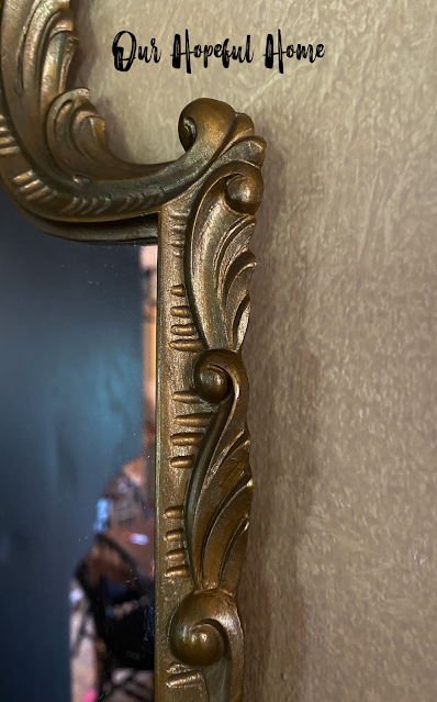 close-up of intricate details on gold mirror frame