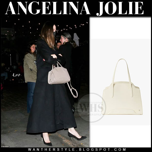 Angelina Jolie in long black coat with beige top handle bag