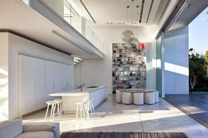Kitchen and dining room in White Ramat Hasharon House by Pitsou Kedem Architects 