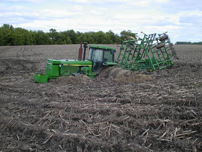 Photo of John Deere tractor stuck in a muddy field.