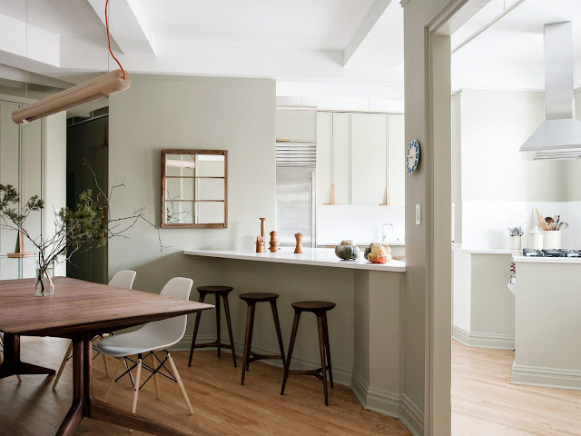 Kitchen overlooking dining room with greige walls and cabinets and wood accents